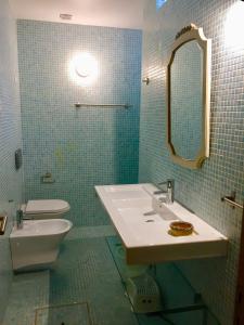 a bathroom with a sink and a toilet and a mirror at Sunset Beach House in Zambujeira do Mar +57 photos