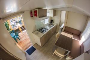 an overhead view of a small kitchen with a table and chairs at SunVillage Camp- Mobilházak Alsóörsön in Alsóörs
