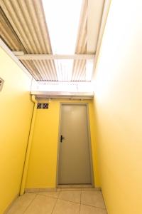 pasillo con puerta en una habitación con tragaluz en KIT 5 - Estúdio com churrasqueira piscina ar wifI vaga cozinha, en Itapema