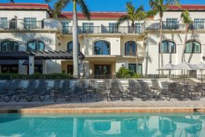 a building with chairs and a pool in front of it at Bellasera Resort in Naples