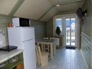 a kitchen with a refrigerator and a table with chairs at Karpatske Vidlunnya in Mykulychyn