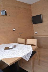 Una mesa de comedor con dos sillas y un televisor. en Apartments Thaler Irina, en Ortisei