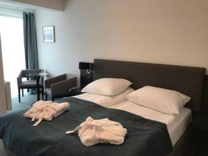 a bed with two towels laying on top of it at Armada Holiday House in Dziwnów