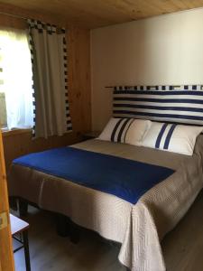 a bedroom with a large bed in a cabin at Cabañas El Sol de Dichato in Dichato