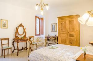 a bedroom with a bed and a table and a mirror at Casino de Matthaeis in LʼAquila