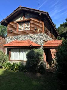 Una casa de madera con una ventana en el costado. en Cabaña Aires del Bosque en Balneario Mar Azul