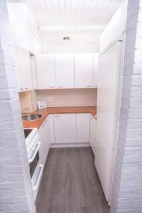 a small kitchen with white cabinets and a sink at Heaven in Pori +16 photos