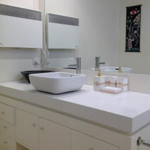 a white bathroom with a sink and two mirrors at Lorne Holiday House in Lorne +11 photos