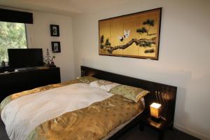 a bedroom with a bed and a picture on the wall at Lorne Holiday House in Lorne