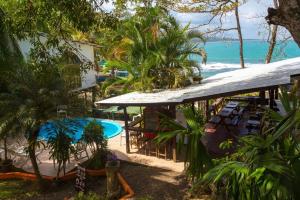 un complejo con piscina y océano en Cabinas Arrecife, en Cahuita