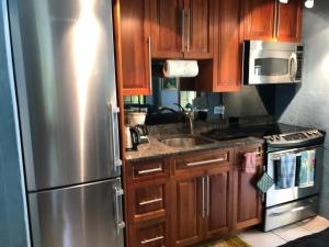 a kitchen with wooden cabinets and a stainless steel refrigerator at Frognal Apartment in North Shore Village