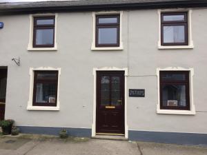 a white house with a black door and windows at The Tailors in Ballyfarnon