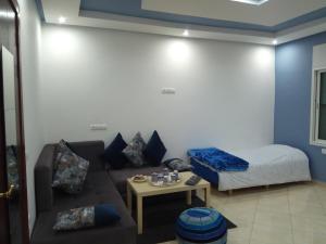 a living room with a couch and a bed at Studios Taha in Rabat