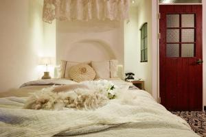 Roseto Hotel في بوتشون: غرفة نوم بسرير ابيض مع باب احمر