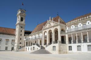 ein Gebäude mit einem Uhrturm und einem Gebäude mit einer Treppe in der Unterkunft Casa da muralha in Figueira da Foz