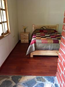 1 dormitorio con 1 cama con edredón en Cabañas Samay Mágico Ecolodge en Huigra