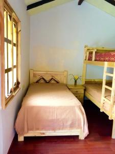 Huigra的住宿－Cabañas Samay Mágico Ecolodge，一间带两张双层床的卧室和两个窗户