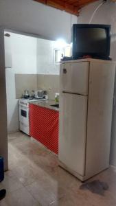 a kitchen with a white refrigerator and a stove at Don Pocho in Mar de Ajó