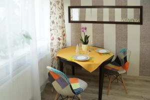 カリーニングラードにあるАпартаменты у Верхнего озера Делюксのダイニングルームテーブル(黄色のテーブルクロスと椅子付)