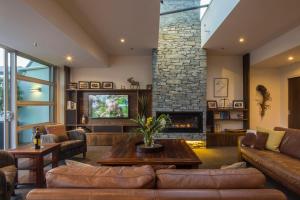a living room with a couch and a fireplace at Shotover Penthouse & Spa by Staysouth in Queenstown