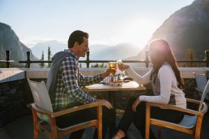 a man and woman sitting at a table drinking beer at Fairmont Banff Springs in Banff