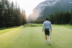 a man is walking on a golf course at Fairmont Banff Springs in Banff