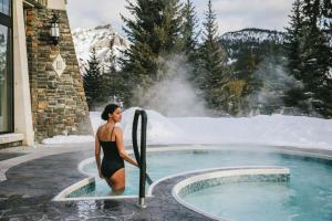 a woman in a bathing suit standing next to a hot tub at Fairmont Banff Springs in Banff