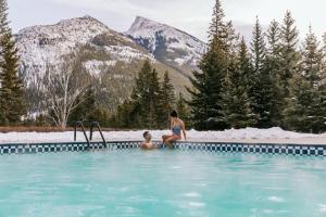 a woman and a child sitting in a swimming pool at Fairmont Banff Springs in Banff