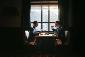 two men sitting at a table drinking wine at Fairmont Banff Springs in Banff