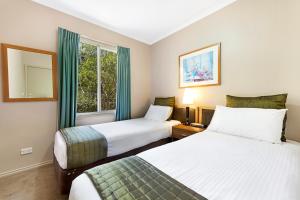 A bed or beds in a room at Punt Road Apartment Hotel