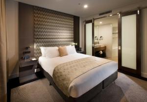 a hotel room with a bed and a dresser at Pullman Brisbane Airport in Brisbane
