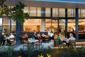 a group of people sitting at tables in a restaurant at ibis Brisbane Airport in Brisbane