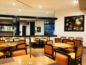 a dining room with wooden tables and chairs at Hotel Harare in Mexico City
