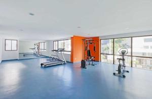 a gym with several treadmills and exercise bikes at Flat 1402 com vista para mar, Edf Home Club Porto do Mar in Recife