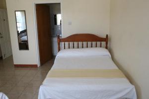 1 dormitorio con 1 cama con sábanas blancas en The Relax Inn, en Saint George