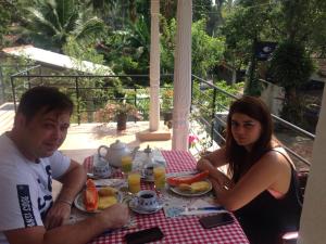 a man and a woman sitting at a table with food at Villa Ok in Unawatuna