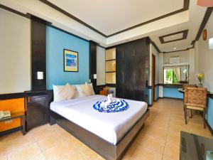 - une chambre avec un grand lit et un bureau dans l'établissement Villa Sunset Boracay, à Boracay