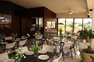 a restaurant with tables and chairs with flowers on them at Hotel Porto Allegro Puerto Vallarta in Puerto Vallarta