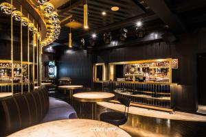 a restaurant with tables and chairs and a bar at The Capsule Hotel in Sydney