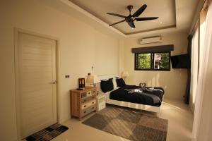 a bedroom with a bed and a ceiling fan at Baan Seaview Holiday Villas in Lamai