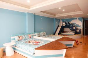 a bedroom with a bed with a blue wall at Kid Baby Homestay in Anping