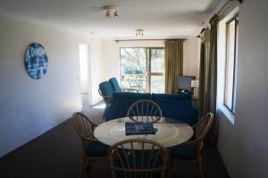 a living room with a blue couch and a table and chairs at Jadon Place Holiday Apartments in Gold Coast
