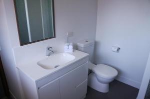 uma casa de banho branca com um lavatório e um WC em Jadon Place Holiday Apartments em Gold Coast