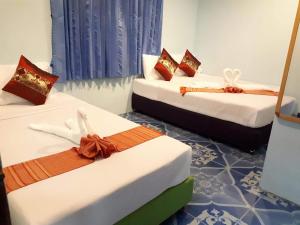 a room with three beds with bows on them at Baan Klong House in Baan Khai