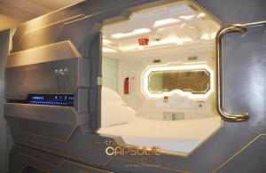 a luxury hotel room with a bed and a large mirror at The Capsule Hotel in Sydney
