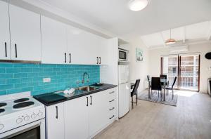 a kitchen with white cabinets and a dining room at West Beach Lagoon 218 - Outstanding Value! in Perth