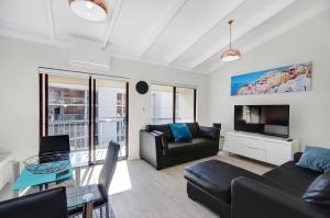 a living room with a couch and a tv at West Beach Lagoon 218 - Outstanding Value! in Perth