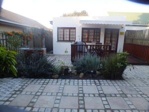 a garden in front of a house with a patio at Twilight Cottage in Plettenberg Bay