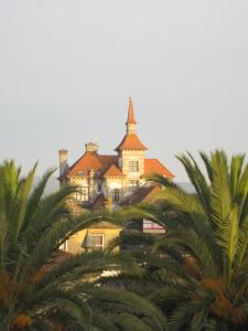 un bâtiment avec une tour au-dessus d'un bâtiment avec des palmiers dans l'établissement Hotel Celta, à A Guarda