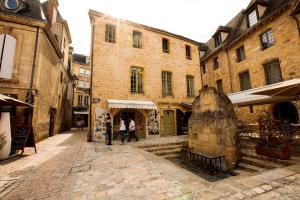 Un groupe de personnes marchant dans une rue avec des bâtiments dans l'établissement Heart of Sarlat, à Sarlat-la-Canéda